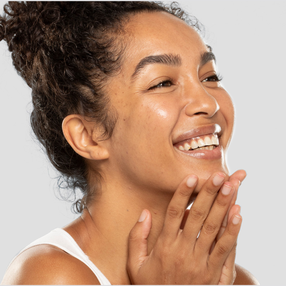A women smiling with her hands on her face